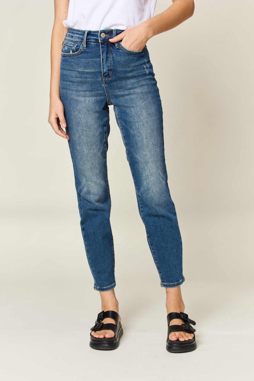 Judy Blue High Waist Slim Jeans in dark denim, featuring tummy control, a zip fly, and a flattering, highly stretchy fit. It has a slim, long leg and high waist.