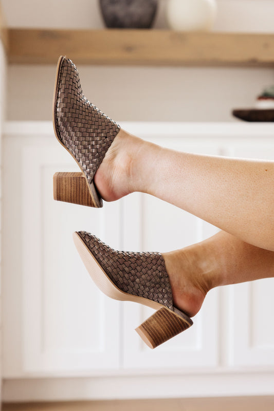 Side angle of woman wearing Teeka Woven Mules in bronze, showing woven detail and wedge heel