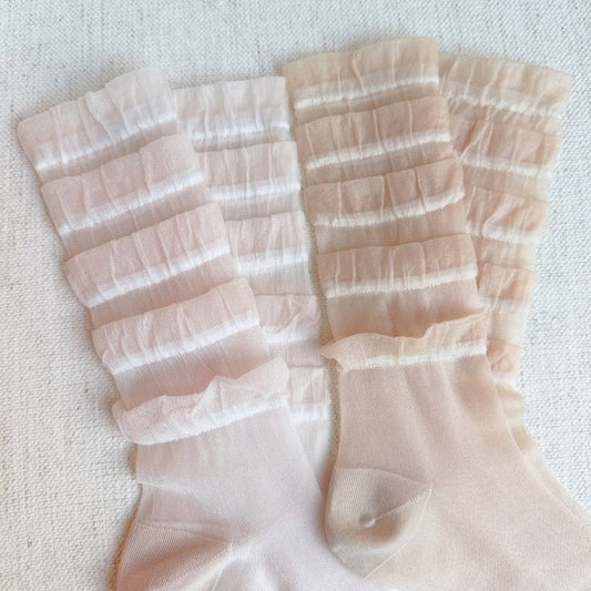 Flat lay of Tulle Lace Cascade Socks Set in pink and beige, showcasing layered lace detail.