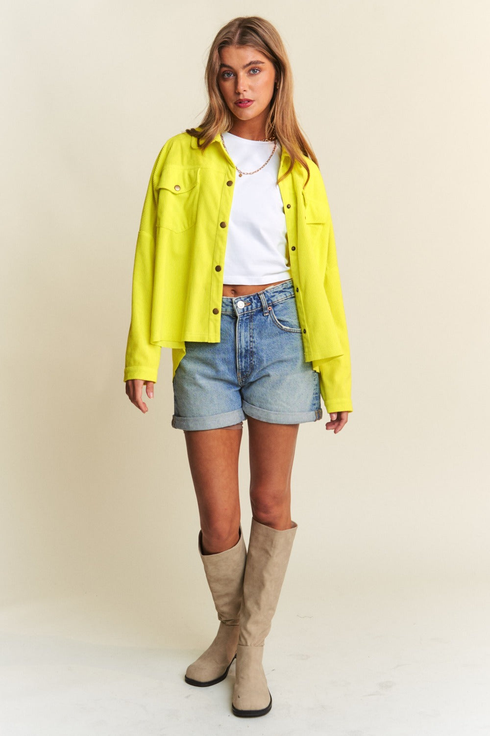 A chartreuse high-low shacket with long sleeves, a collared neckline, and snap-button closure. 