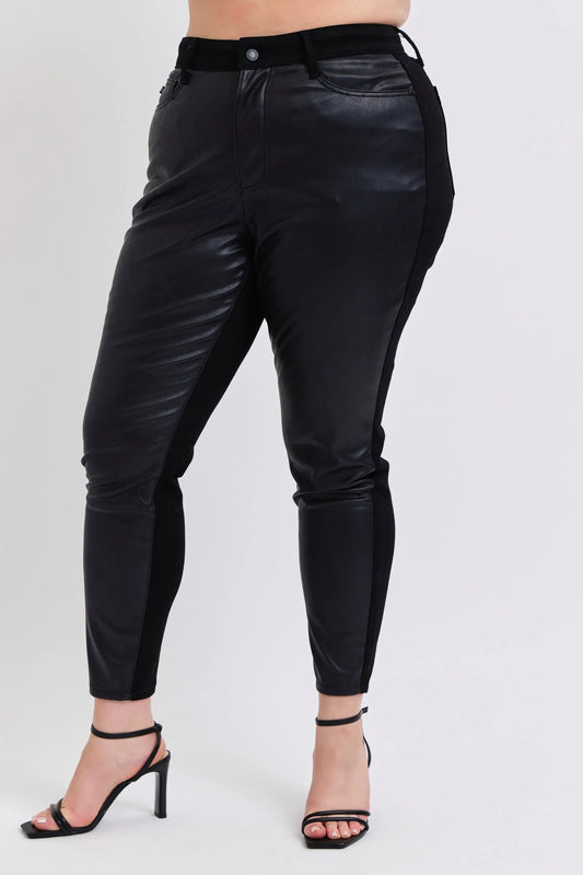Plus model wearing Kat black faux leather skinny pants, high-waisted fit with pockets, sleek curve-flattering design.