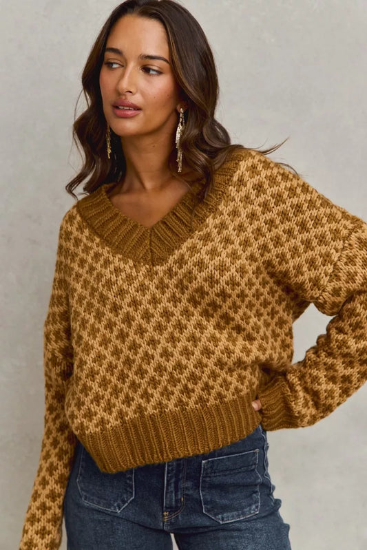 Woman front view wearing Chloe color block textured V-neck sweater in caramel with diamond knit design.