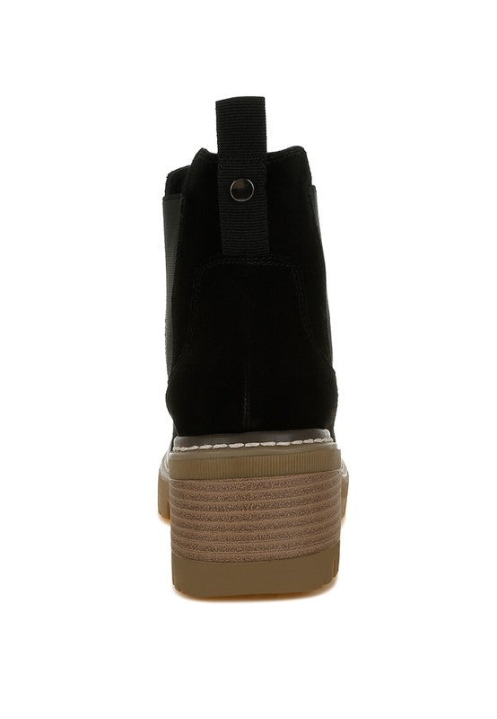 Rear view of black Chelsea boots with pull tabs and lug sole