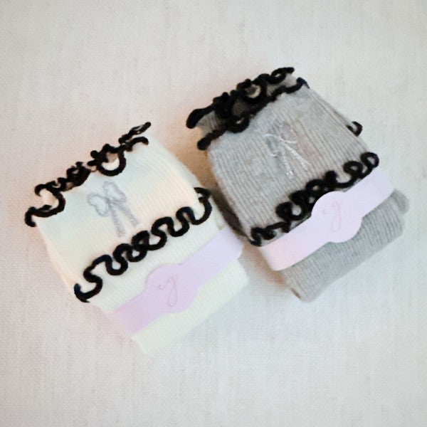 Folded set of Ribbon Ripple Socks in cream and grey stacked together.
