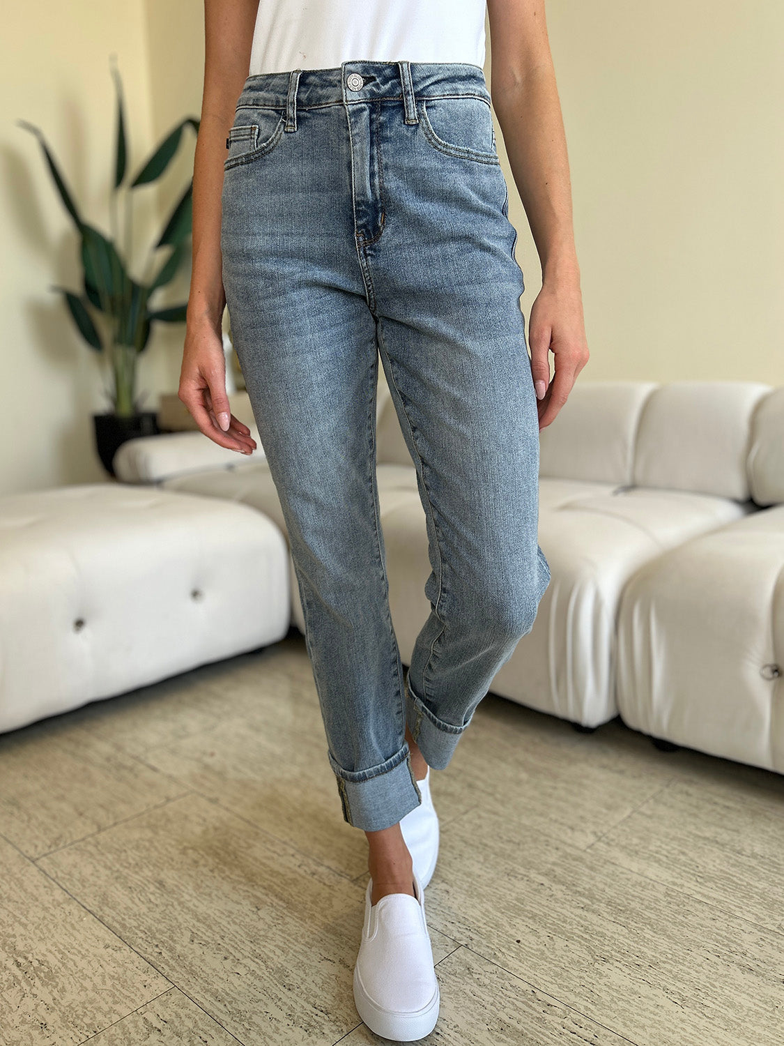 Medium wash high-rise skinny jeans with cuff hem, featuring moderate stretch.