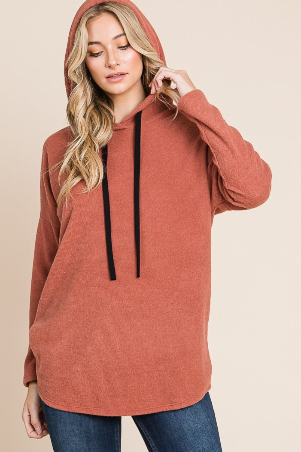 Warm brick hoodie with a black drawstring hood, long sleeves, and a relaxed fit. Features a soft brushed interior and dropped shoulders.