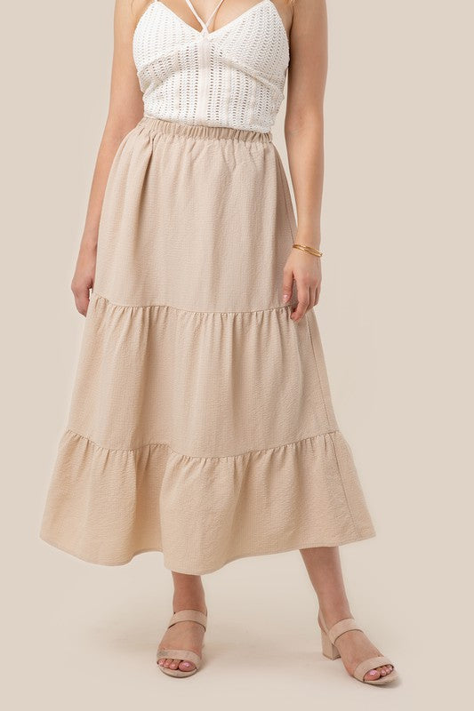 Tiered maxi skirt with elastic waistband in beige. Flowy silhouett, lined for full coverage.