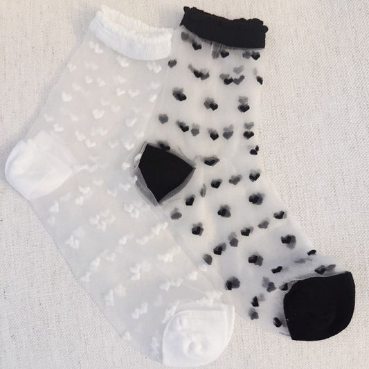 Flat lay of black and white Sweet Hearts Sheer Socks with delicate heart design.