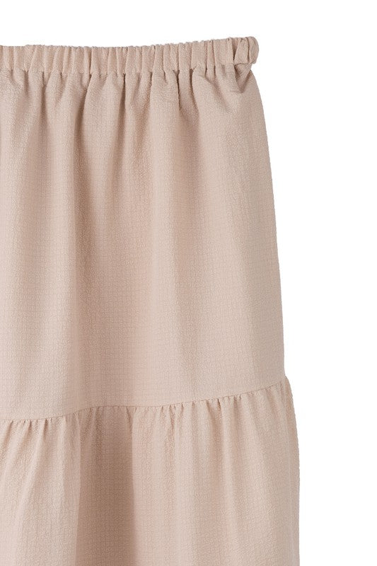 Tiered maxi skirt with elastic waistband in beige. Flowy silhouett, lined for full coverage.