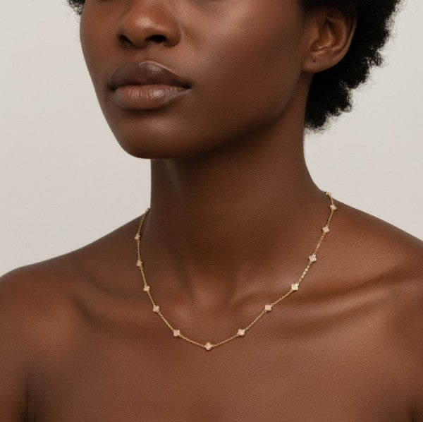 Model showing Petite Colored Clover Necklace in cream clover design detail.