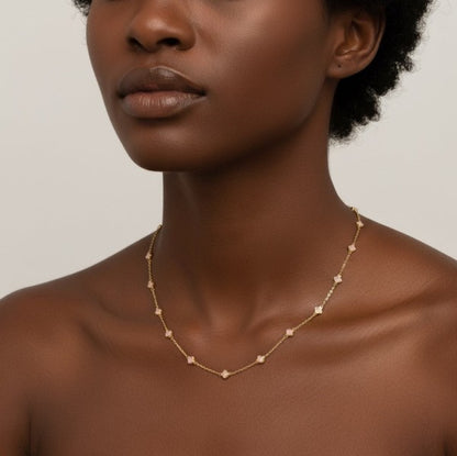 Model showing Petite Colored Clover Necklace in cream clover design detail.