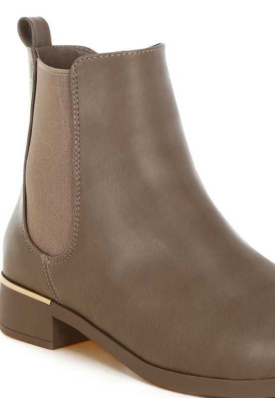 Close-up of taupe Chelsea boot showing textured side elastic panel.