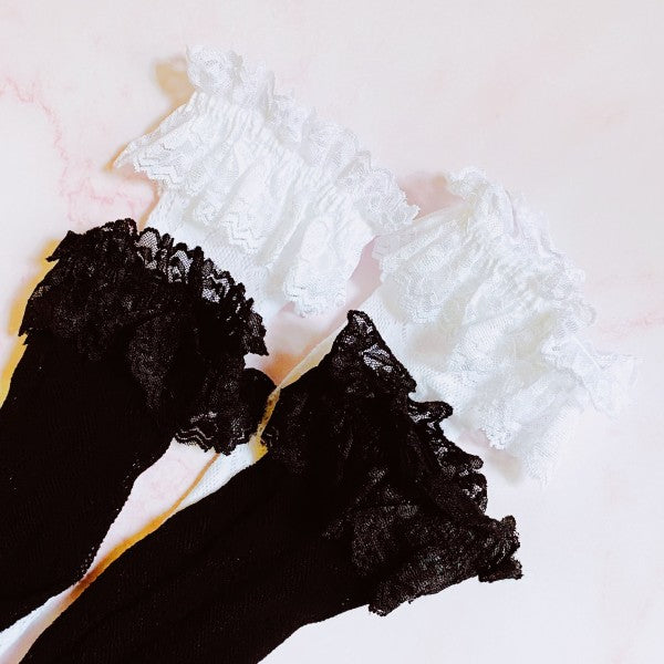 Flat lay of black and white lace socks with delicate lace pattern and double ankle layer.
