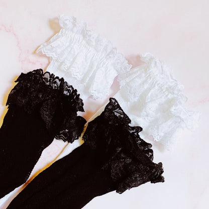 Flat lay of black and white lace socks with delicate lace pattern and double ankle layer.