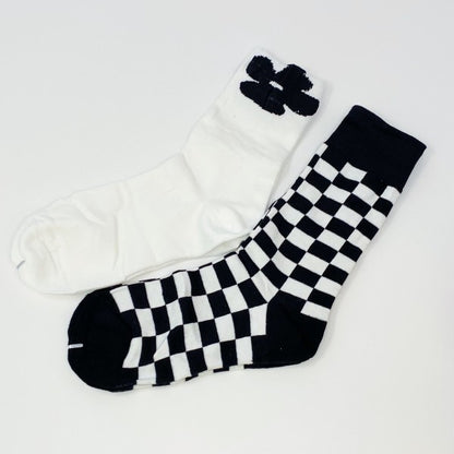 Flat lay of Insiders Only Sock Set with white flower pair and black-and-white checkered pair.