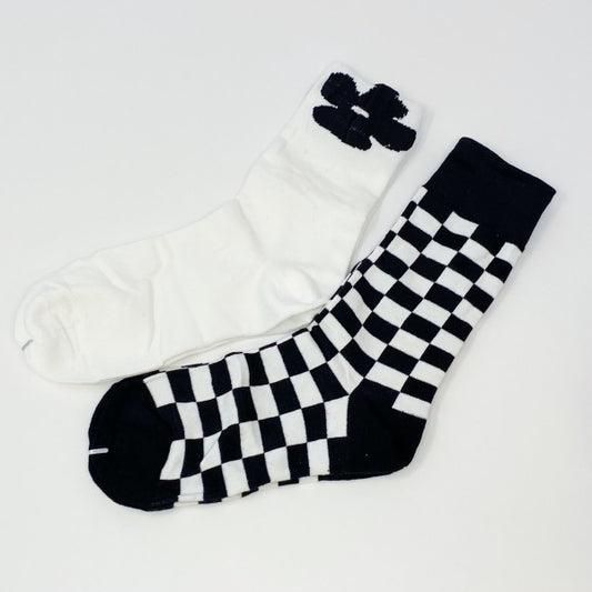 Flat lay of Insiders Only Sock Set with white flower pair and black-and-white checkered pair.