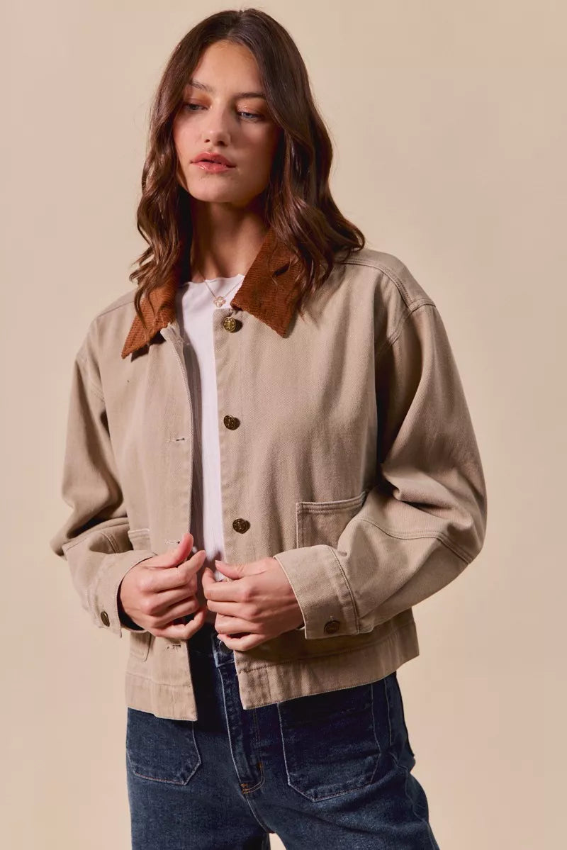 Model wearing Suri Cotton Twill Cropped Barn Jacket in Taupe with collared neckline.