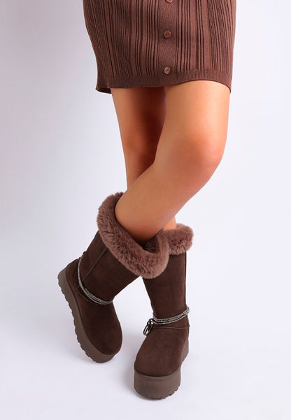 Brown boots on model showing rounded toe and anti-skid tread.