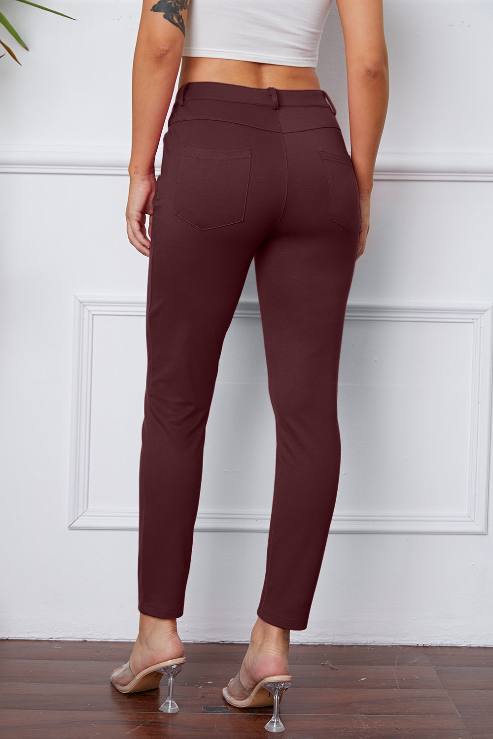 Wine stretchy high-waisted pants feature pockets, a zip fly, and belt loops. 