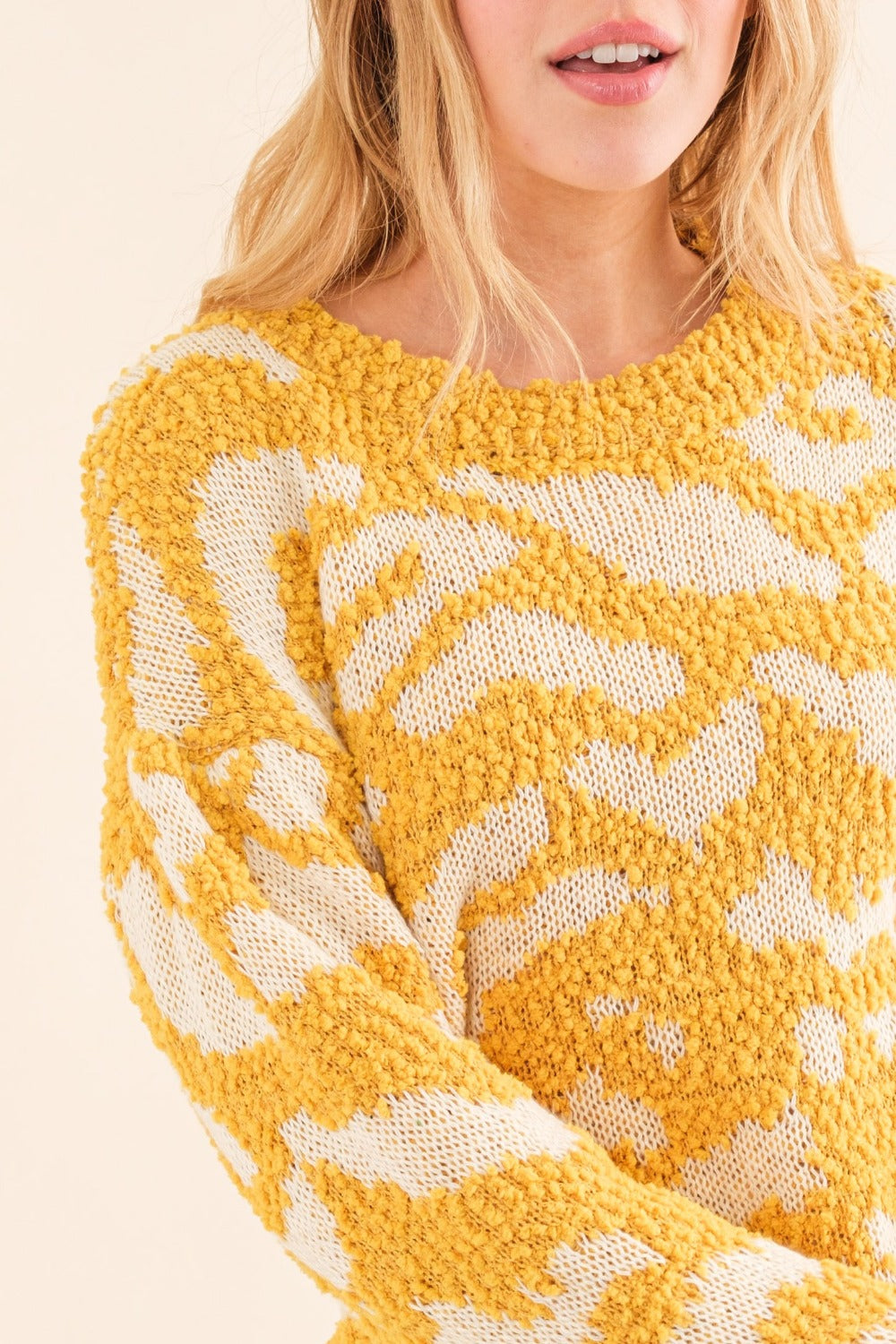 Women's textured mustard sweater with a round neckline and long sleeves.