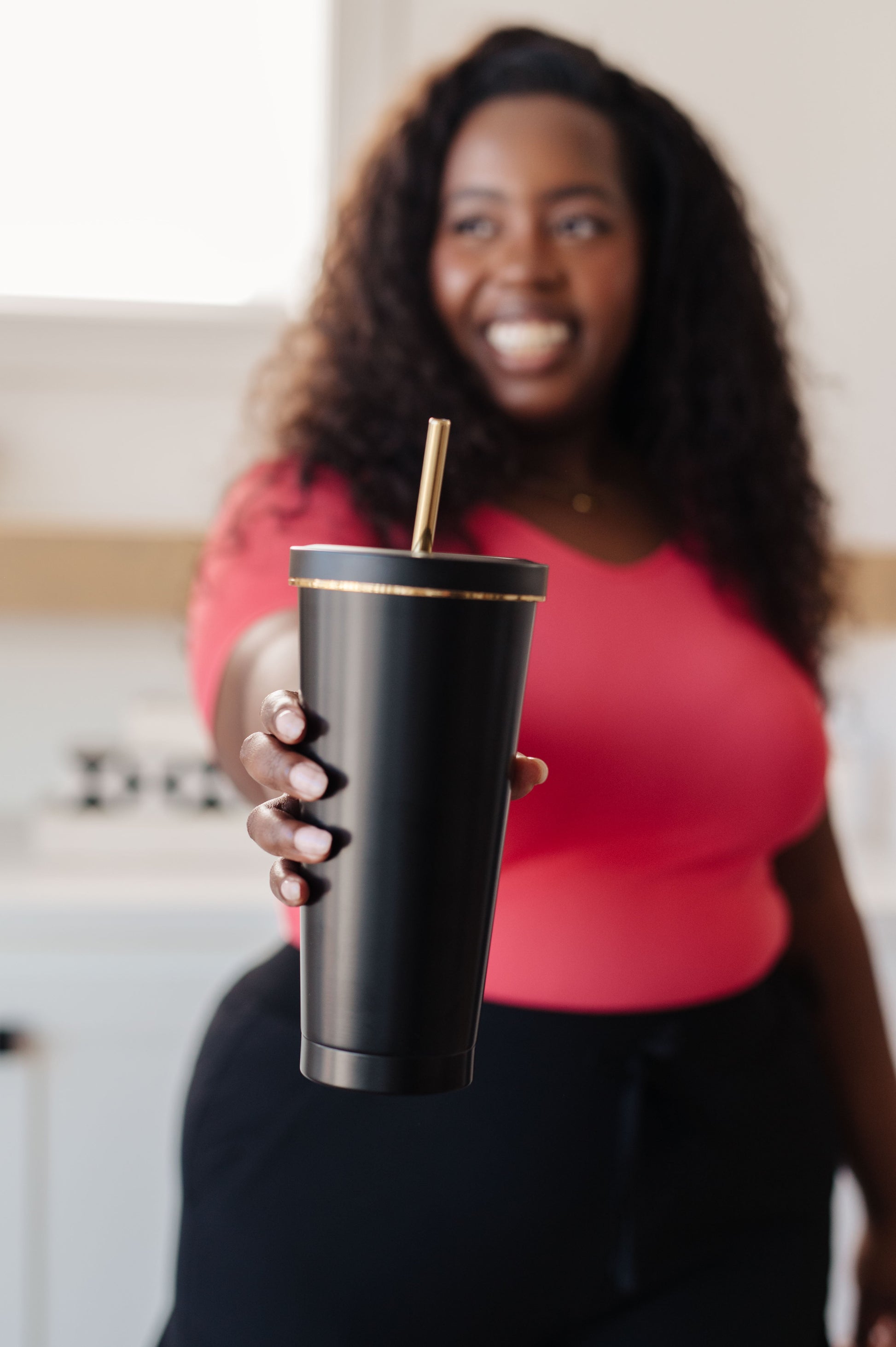 Black tumbler with gold accents, 25 oz capacity, made of double-layer stainless steel, includes a matching straw and cleaning brush.