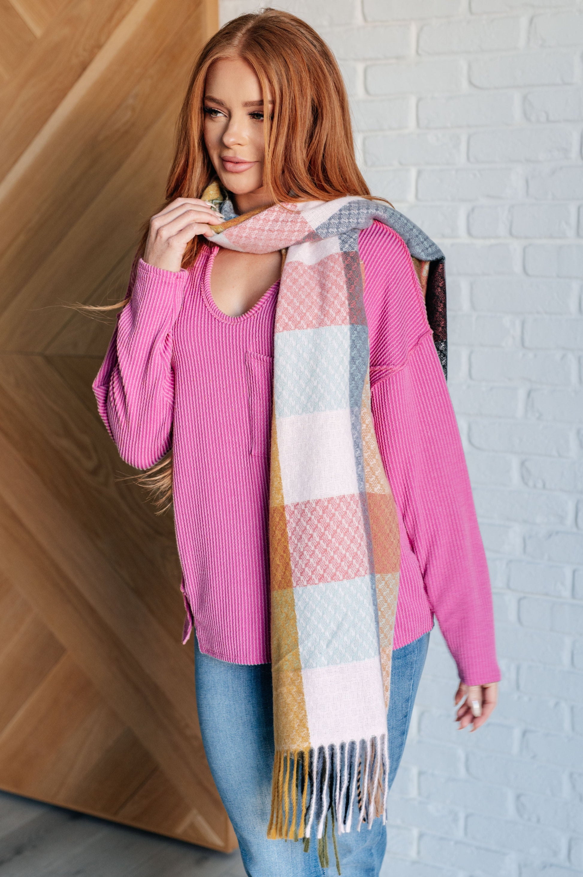 Women's cozy checkered fringe scarf in pink, yellow and gray, made from warm brushed fabric with playful fringe. Versatile for layering as a scarf or shawl to elevate any outfit.