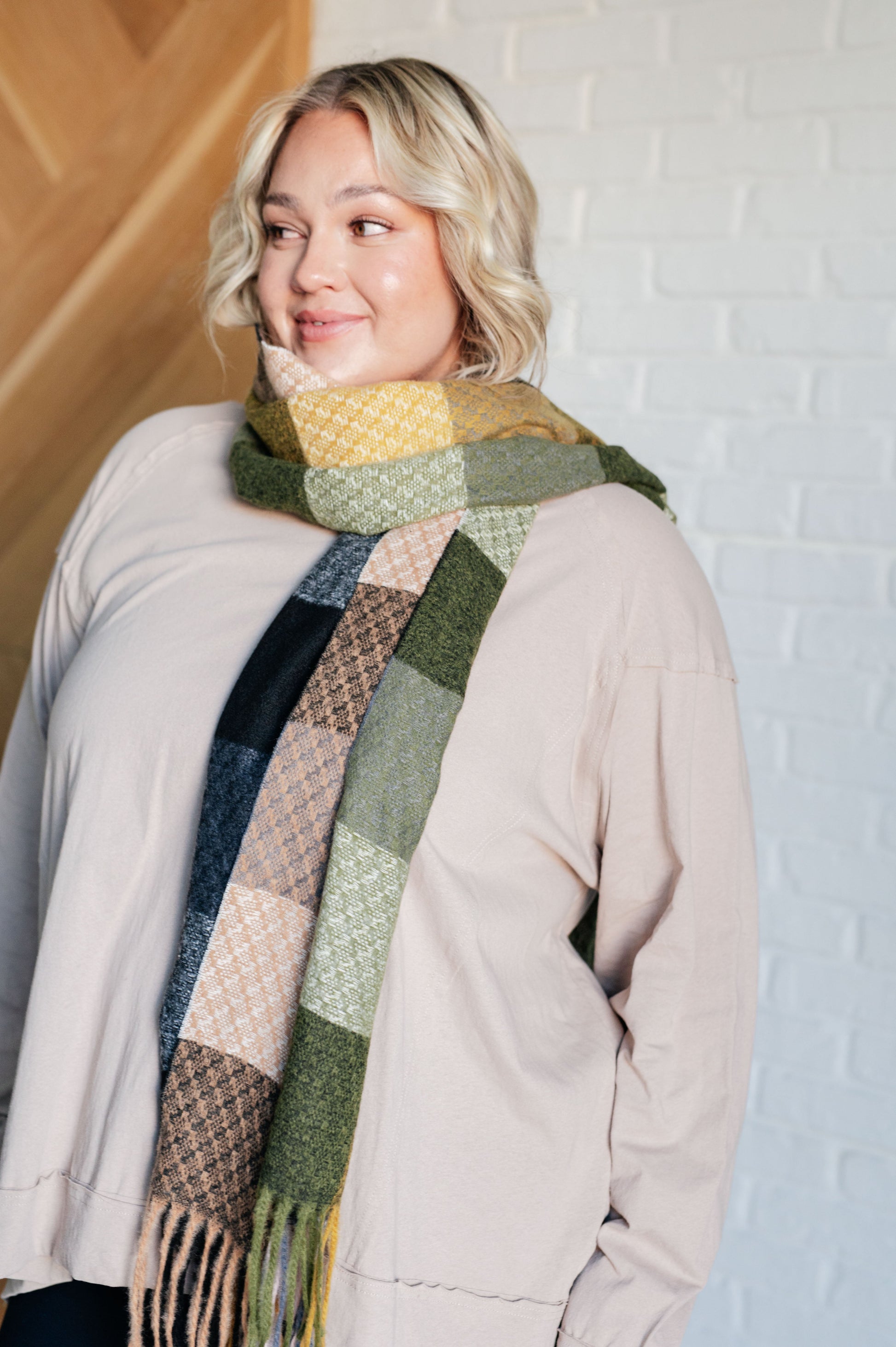 Women's cozy checkered fringe scarf in green,blue,  yellow and tan, made from warm brushed fabric with playful fringe. Versatile for layering as a scarf or shawl to elevate any outfit.