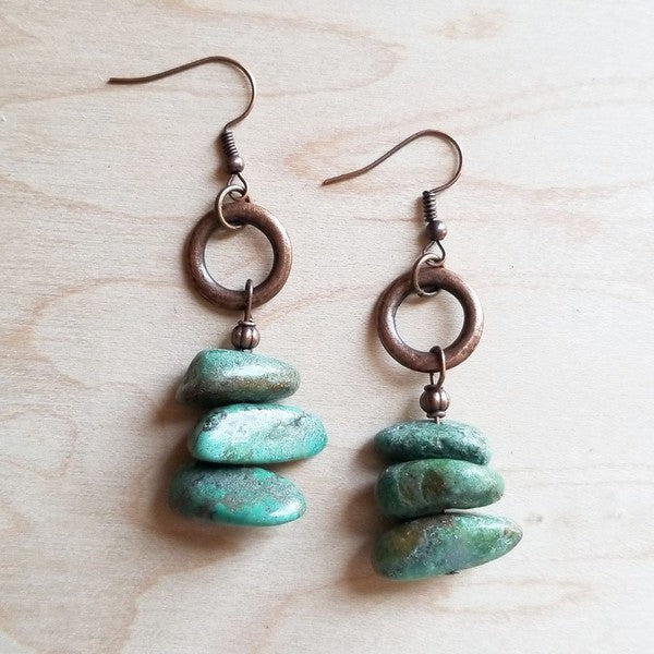 Handcrafted earrings featuring natural turquoise chunks stacked on copper hoops, measuring 2" in length. 