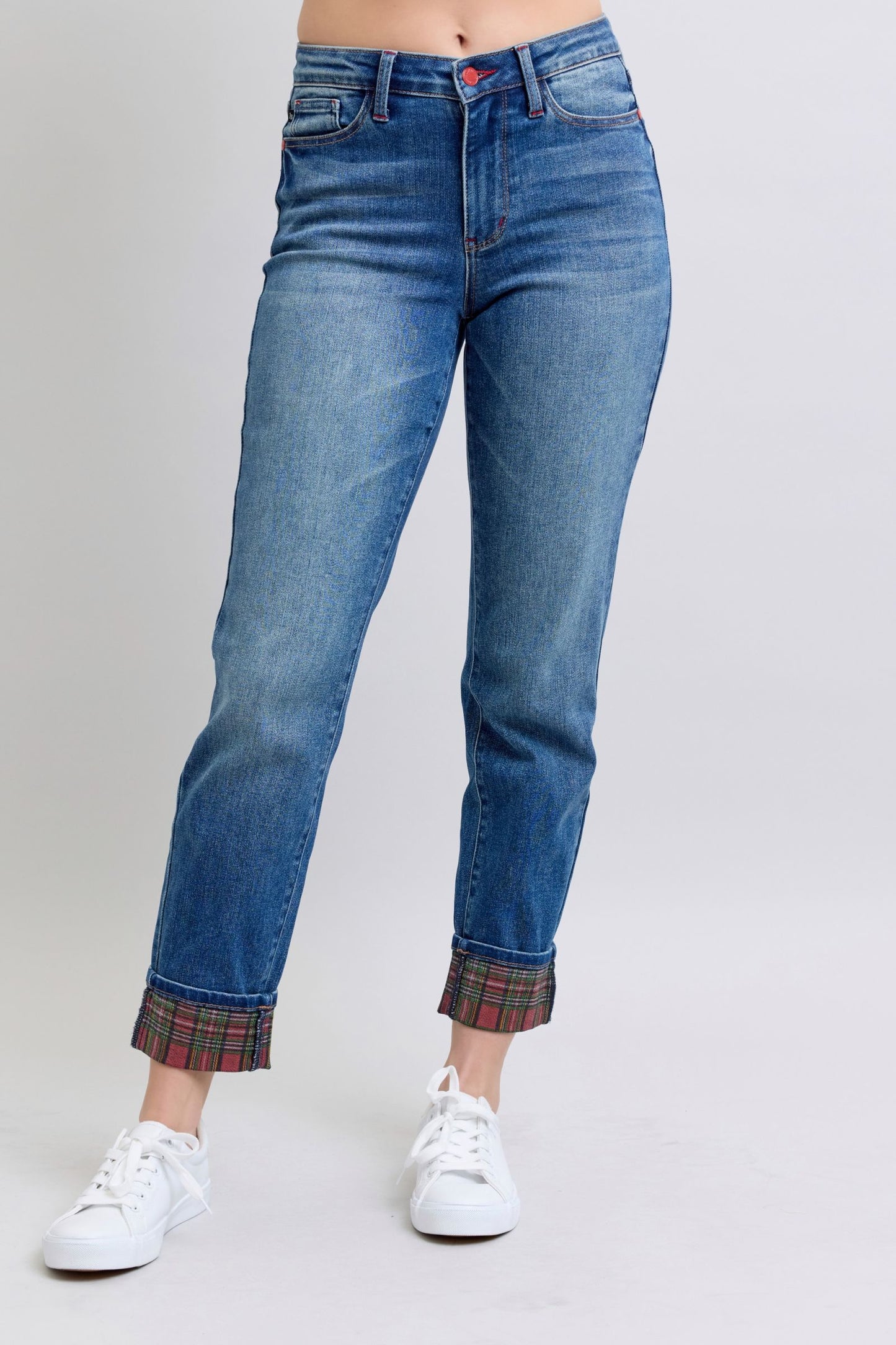 Women's mid rise, medium-wash straight-leg jeans with red and green plaid cuffs.