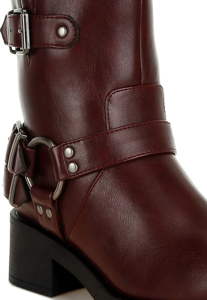 Close-up of burgundy Caribou Boots showing vegan leather and bold harness accents.