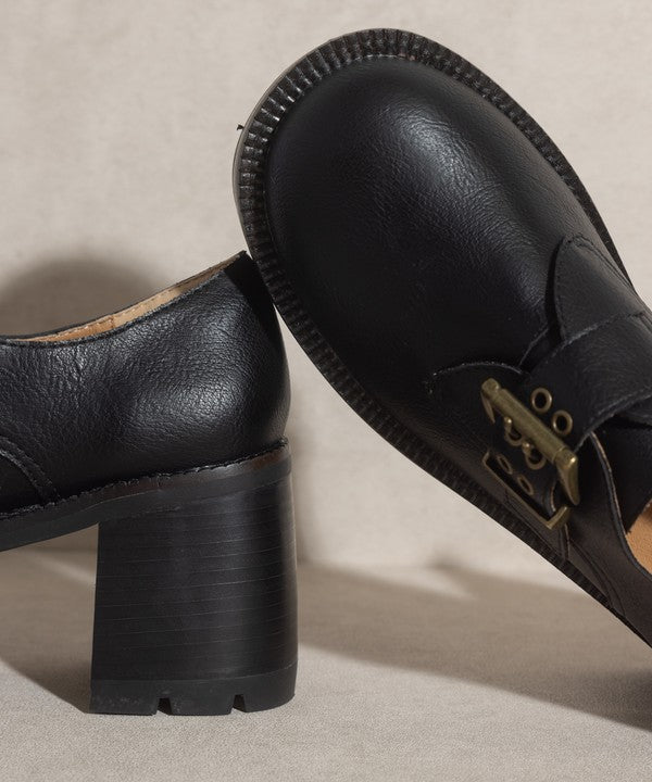 Black buckled platform loafers with e-inch heel, 1.5-inch front platform, and buckle closure.