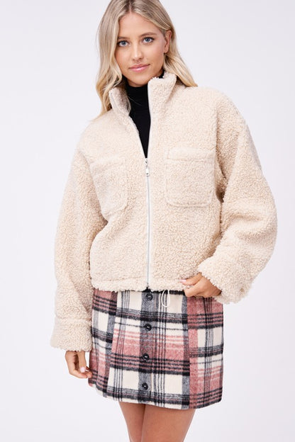 Front view of cream sherpa jacket styled with black turtleneck