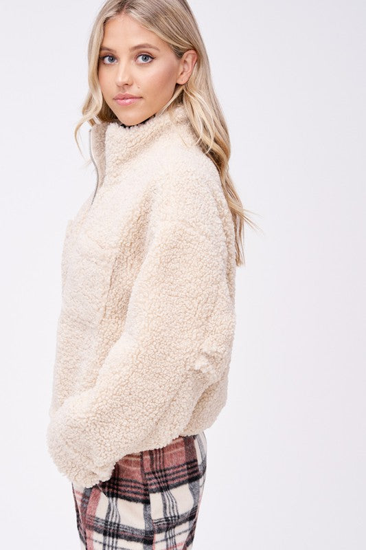 Side view of cream sherpa jacket highlighting soft texture and pockets