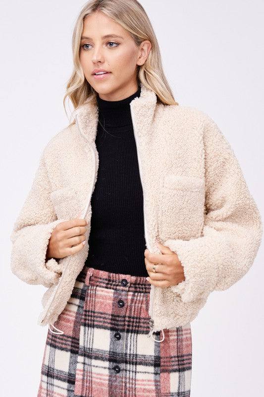 Front close-up of cream sherpa jacket highlighting texture and details