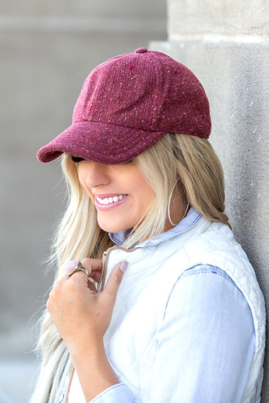 Woman wearing Faryn Fall Tweed Ball Cap in Cranberry with fall-ready texture and adjustable clasp