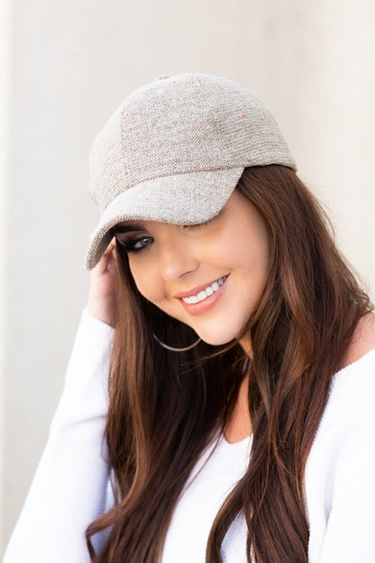 Woman wearing Faryn Fall Tweed Ball Cap in Stone with structured crown and antique bronze clasp.