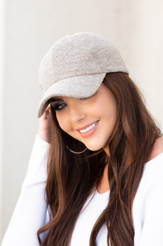 Woman wearing Faryn Fall Tweed Ball Cap in Stone with structured crown and antique bronze clasp.