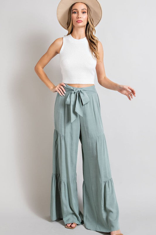 Mint wide-leg, tiered pants with a smocked waist and tie front, offering a comfortable, oversized fit for a relaxed, casual look.