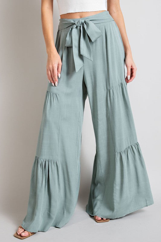 Mint wide-leg, tiered pants with a smocked waist and tie front, offering a comfortable, oversized fit for a relaxed, casual look.