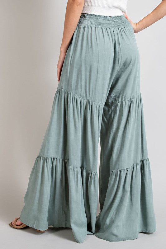 Mint wide-leg, tiered pants with a smocked waist and tie front, offering a comfortable, oversized fit for a relaxed, casual look.