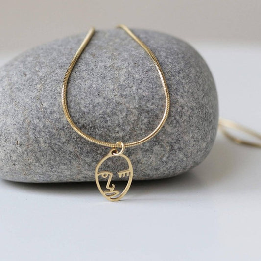 18K Gold-plated stainless steel necklace with a Picasso face pendant, adjustable chain, and minimalist design.