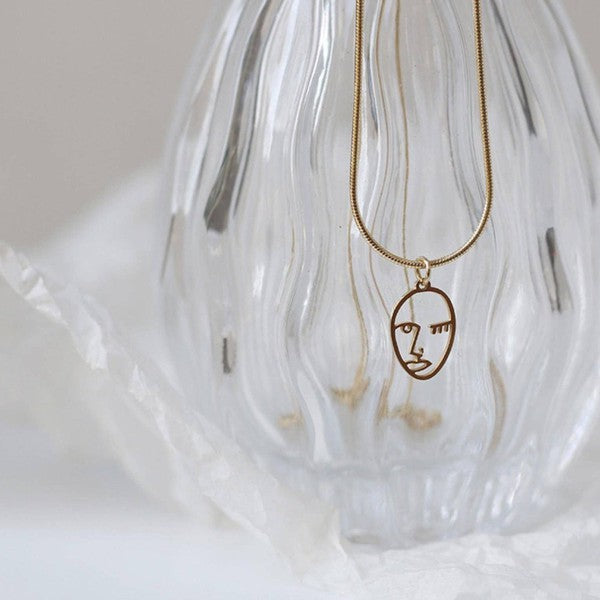 18K Gold-plated stainless steel necklace with a Picasso face pendant, adjustable chain, and minimalist design.