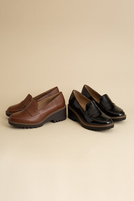 Chunky loafers in black and cognac feature a sleek design with a 2.3" heel.