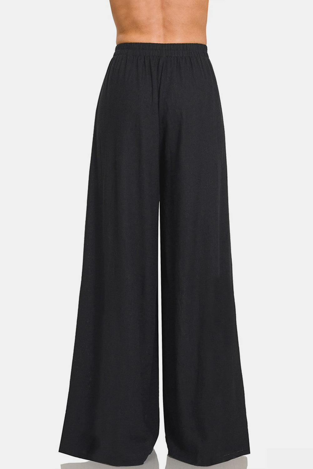 Black high-waisted pleated wide leg pants, elastic waist, made from a linen blend fabric.