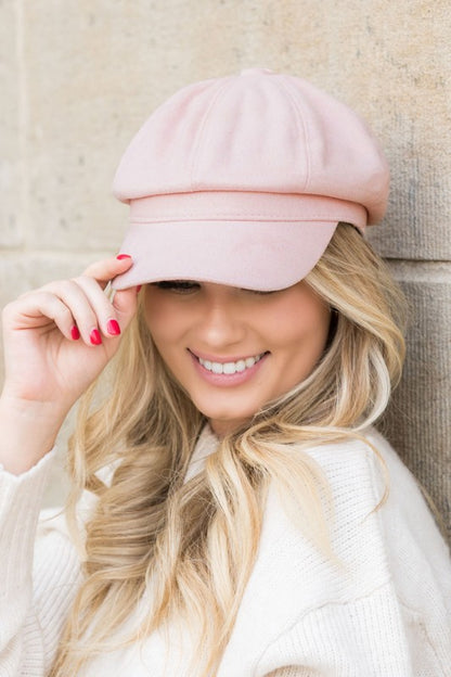 Woman wearing Gidget Suede Newsboy Cap in Blush, soft faux suede with structured bill and adjustable fit