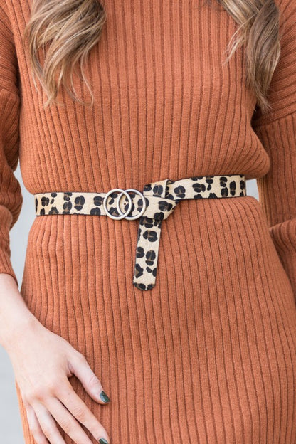 Woman wearing leopard Double O-Ring Belt with dress for a bold chic look.