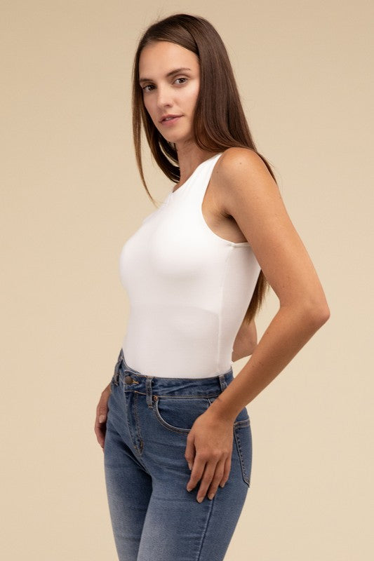 Sleeveless bodysuit in bone with a boat neckline, padded bodice, and removable bra pads for adjustable comfort.