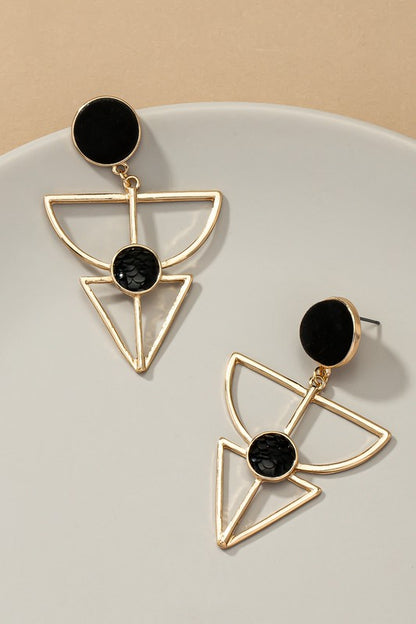 Gold earrings feature a velvet stud, geometric cutout design, and a textured black stone embedded in the cutout. They are 2.5 inches long.
