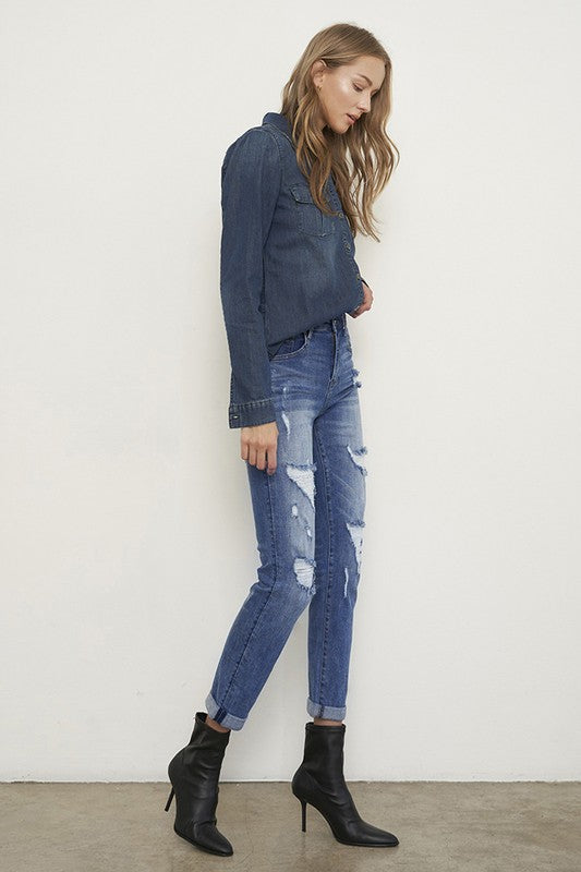 Medium wash distressed girlfriend jeans with a slim fit, mid-rise waist, button closure, and ankle-length cut.