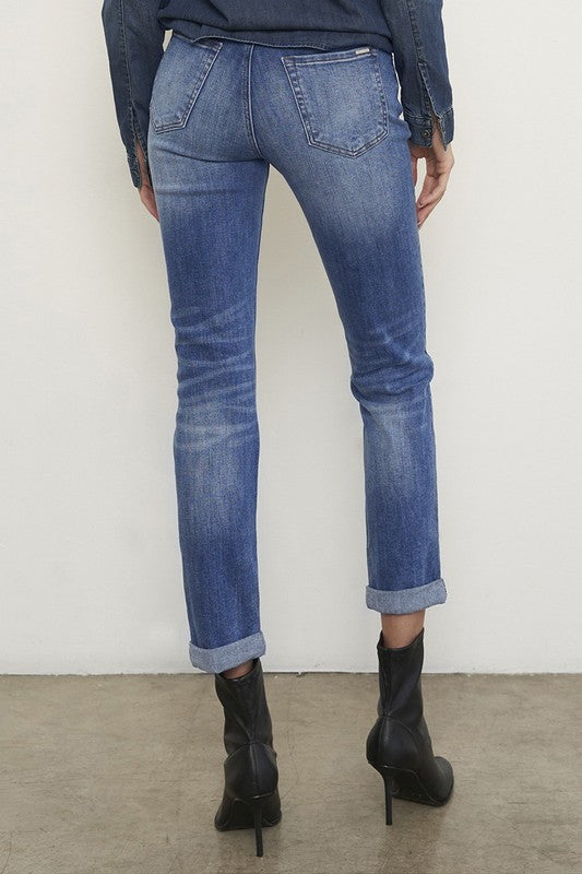 Medium wash distressed girlfriend jeans with a slim fit, mid-rise waist, button closure, and ankle-length cut.